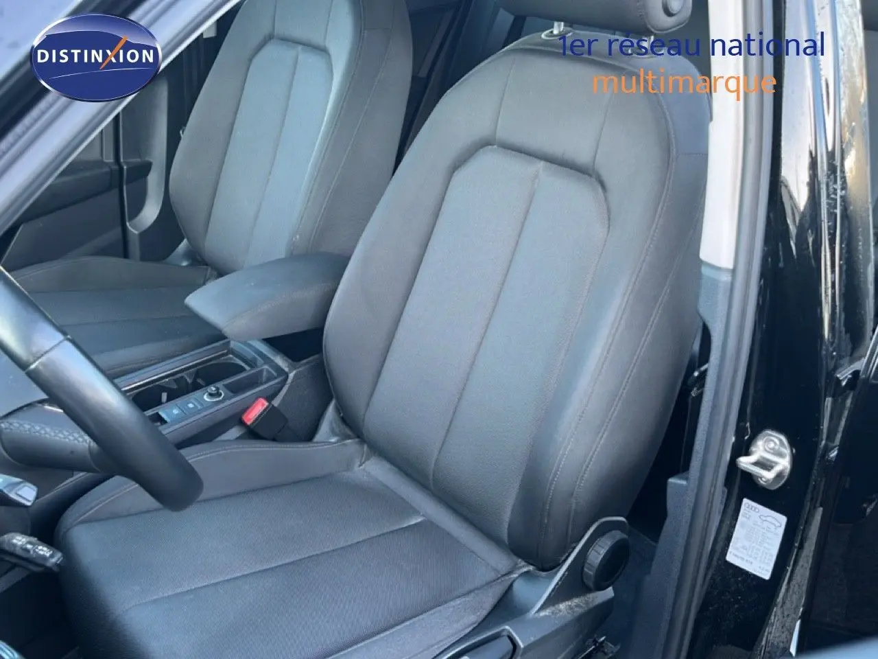 Vue intérieure montrant les sièges avant noirs de l'Audi Q3 Sportback 35 TDI 150 S-Line, porte ouverte côté conducteur.