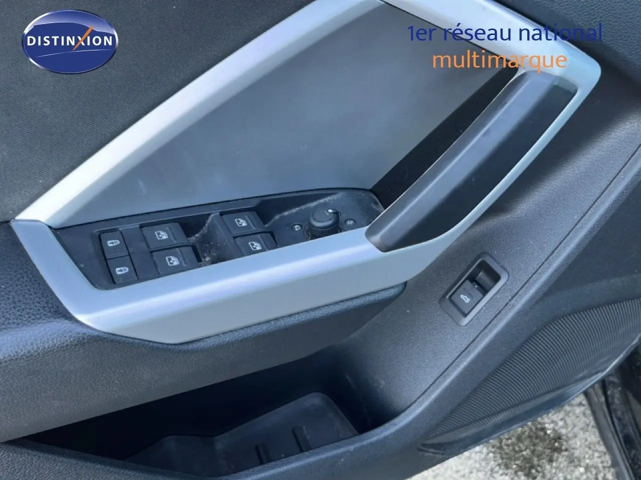Gros plan sur la commande des vitres et le bouton de déverrouillage sur la porte côté conducteur d’un Audi Q3 Sportback noir.