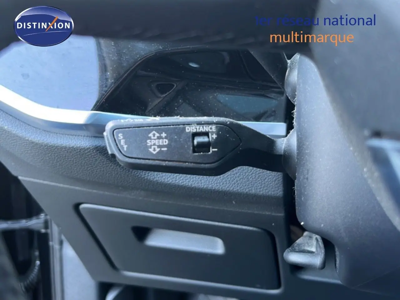 Gros plan sur la commande de régulateur de vitesse au volant d’un Audi Q3 Sportback noir, vue intérieure côté conducteur.
