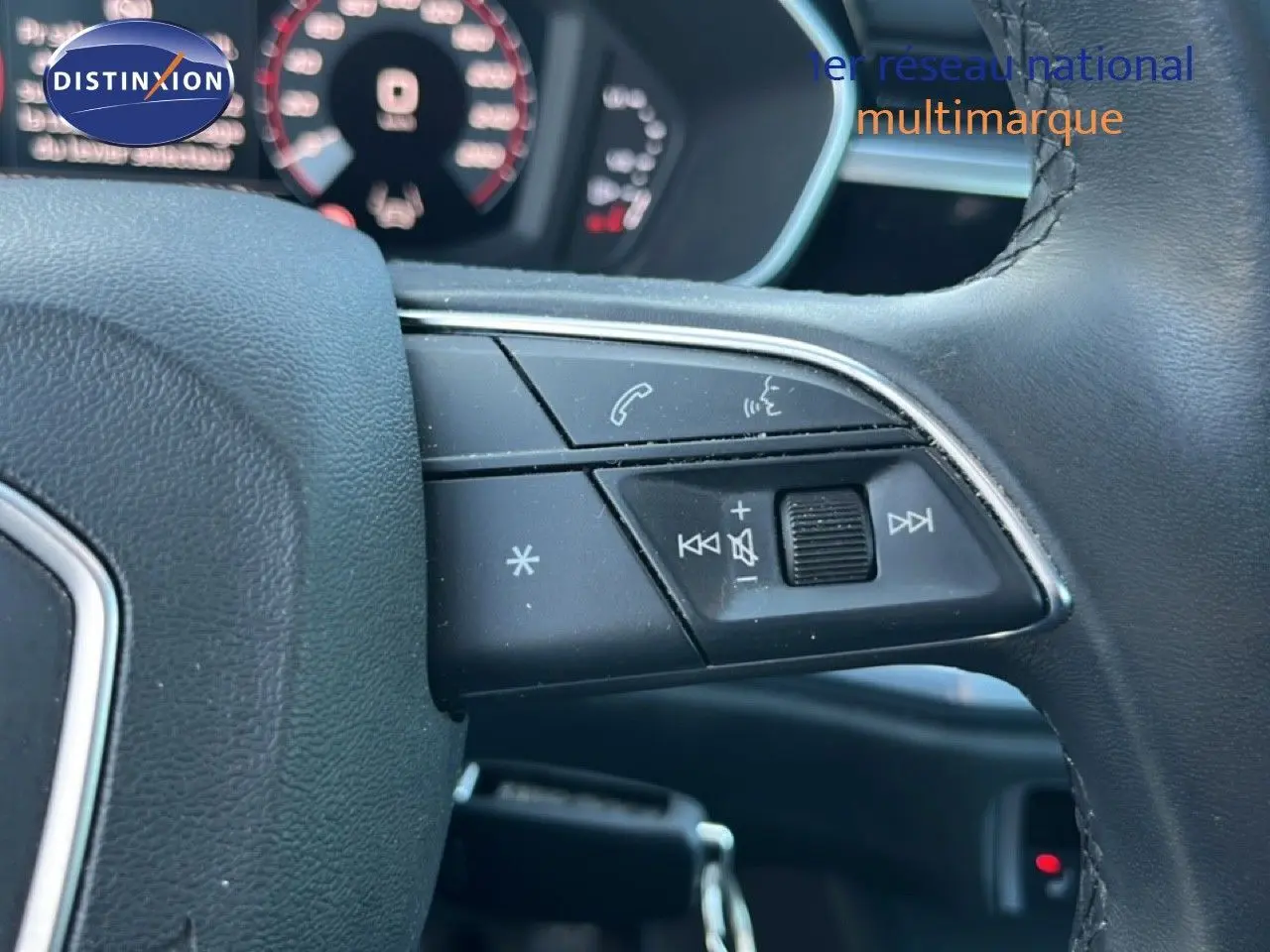 Gros plan sur les commandes au volant à droite de l'Audi Q3 Sportback noir, avec tableau de bord numérique en arrière-plan flou.