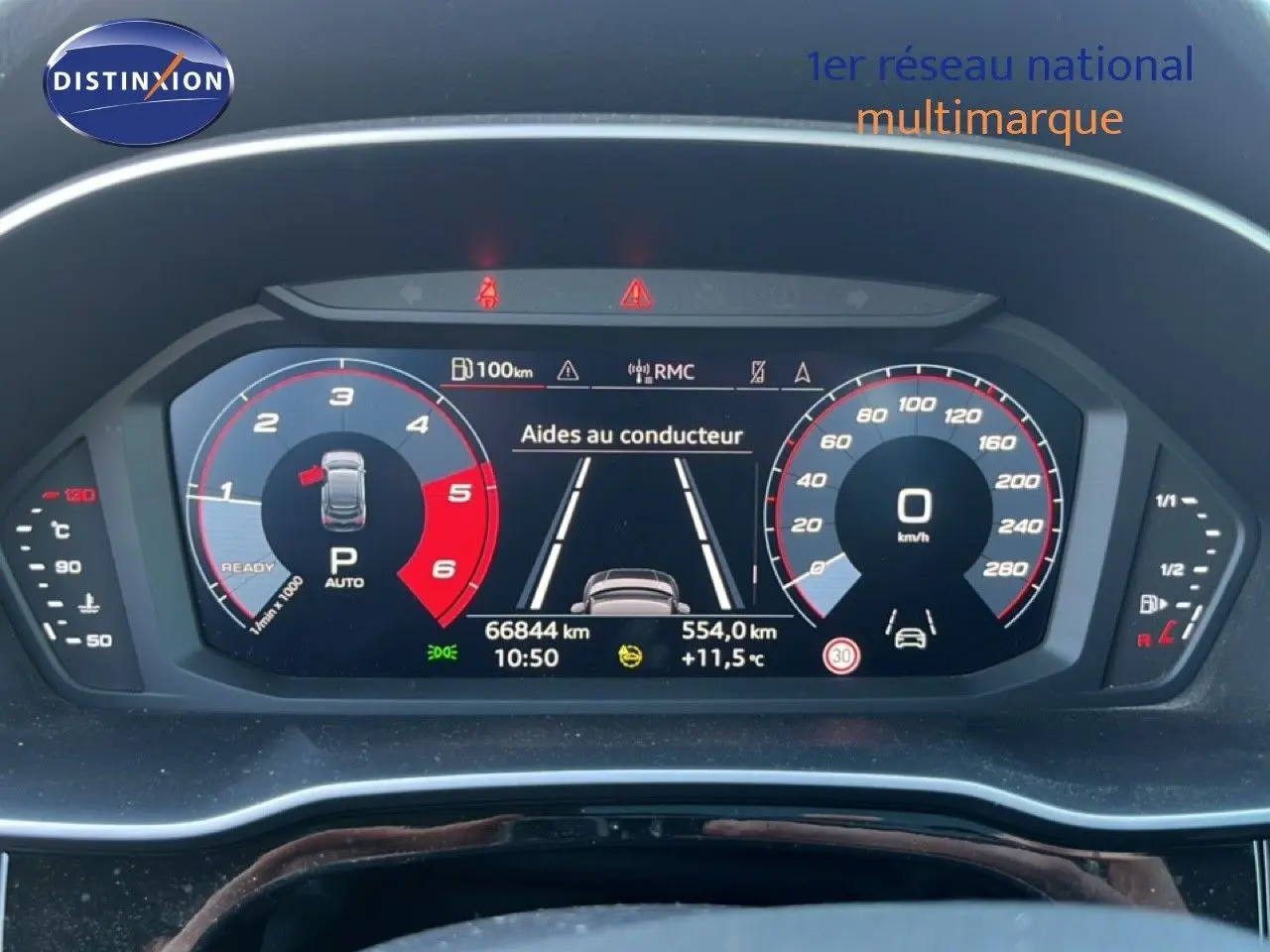 Vue rapprochée du tableau de bord numérique de l'Audi Q3 Sportback noir, affichant les aides au conducteur et compteurs.