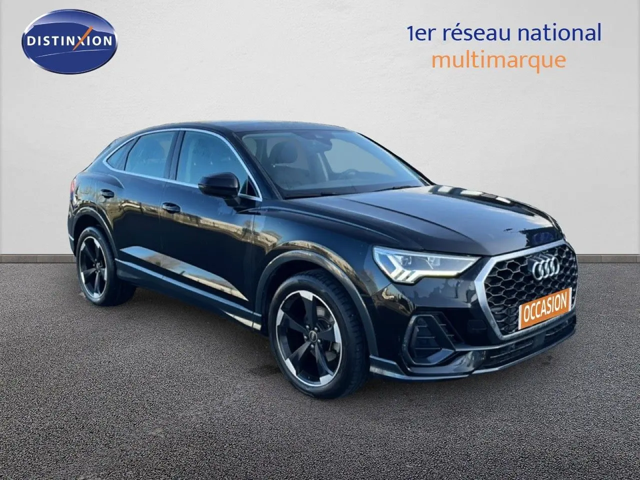 Audi Q3 Sportback noir vue 3/4 avant droit, avec calandre hexagonale et jantes noires distinctives.