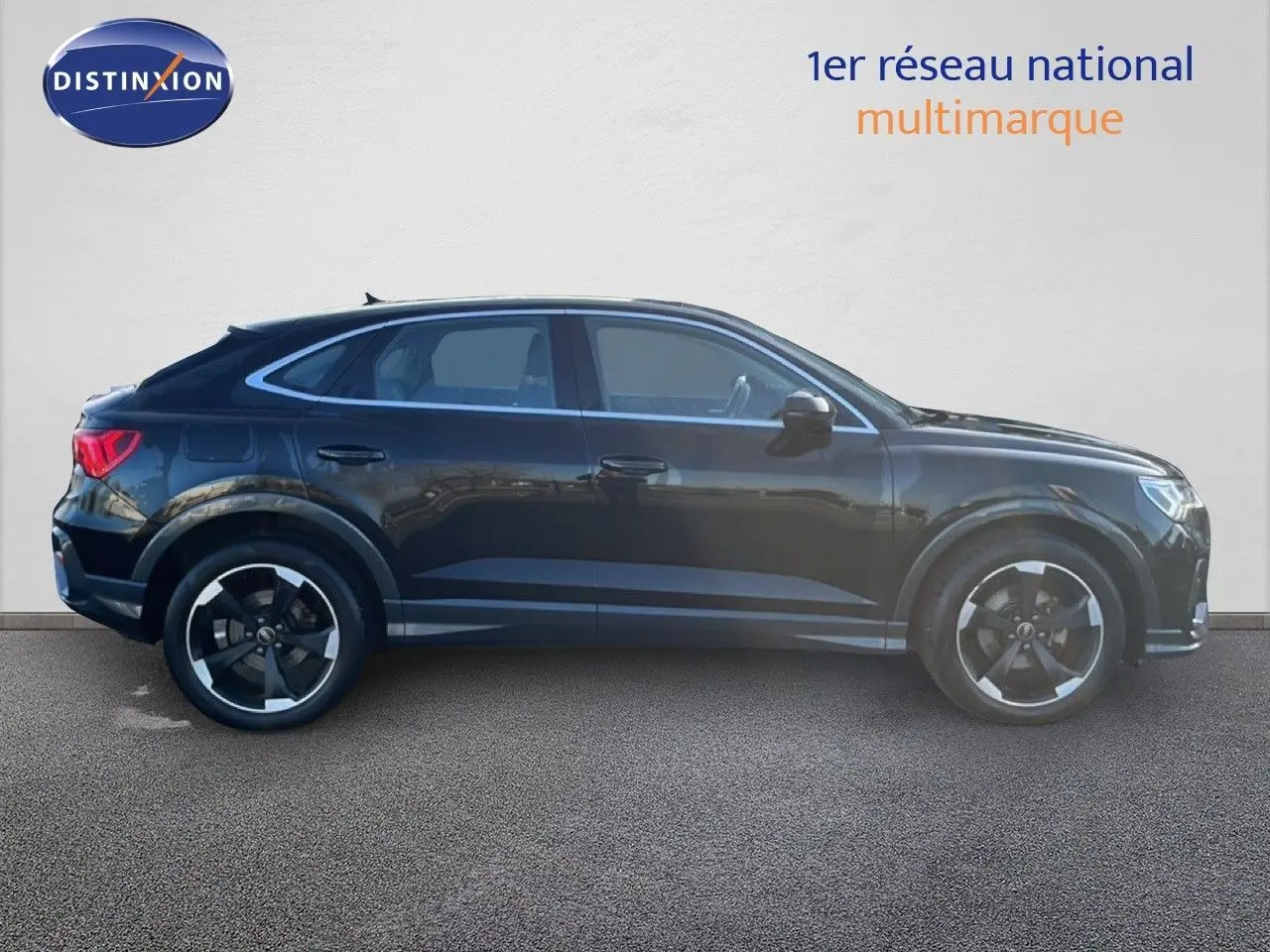 Audi Q3 Sportback noir vue de profil côté gauche, soulignant sa silhouette coupée et ses jantes noires distinctives.