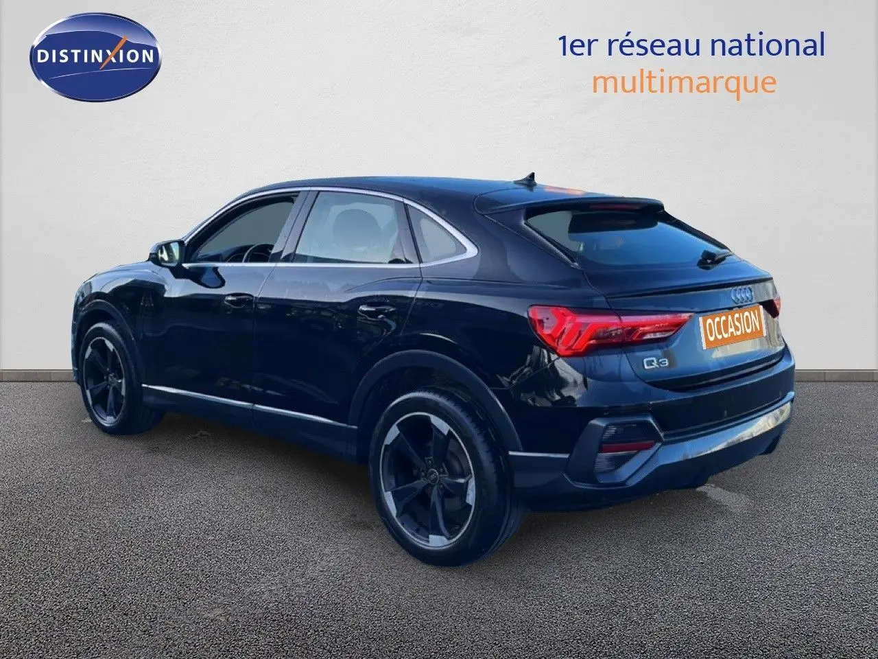 Audi Q3 Sportback noir vue 3/4 arrière droit, mettant en valeur ses feux arrière LED et ses jantes noires.