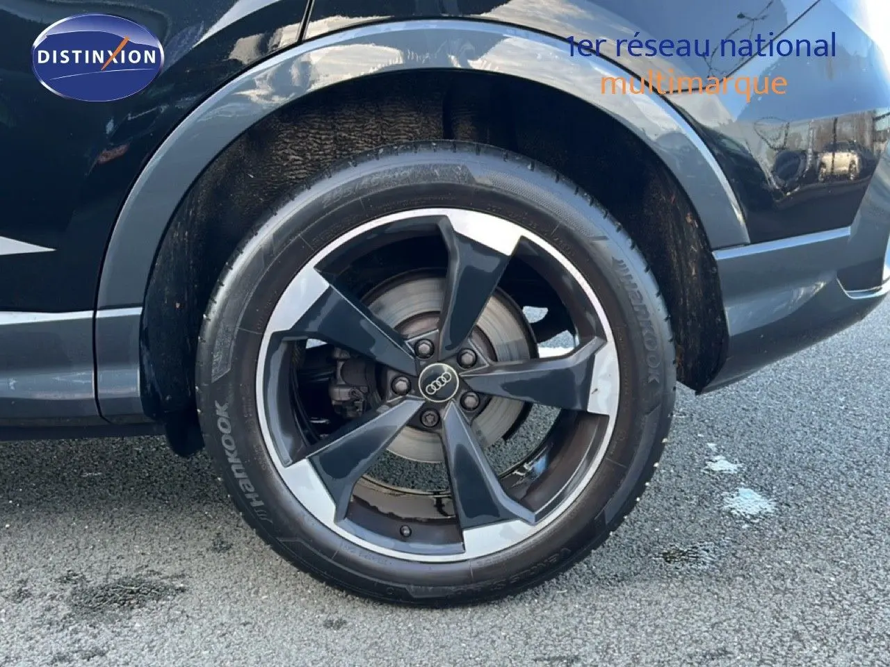 Gros plan sur la roue avant droite noire d’un Audi Q3 Sportback 35 TDI 150 S-Line 2022 avec jante alliage bicolore.