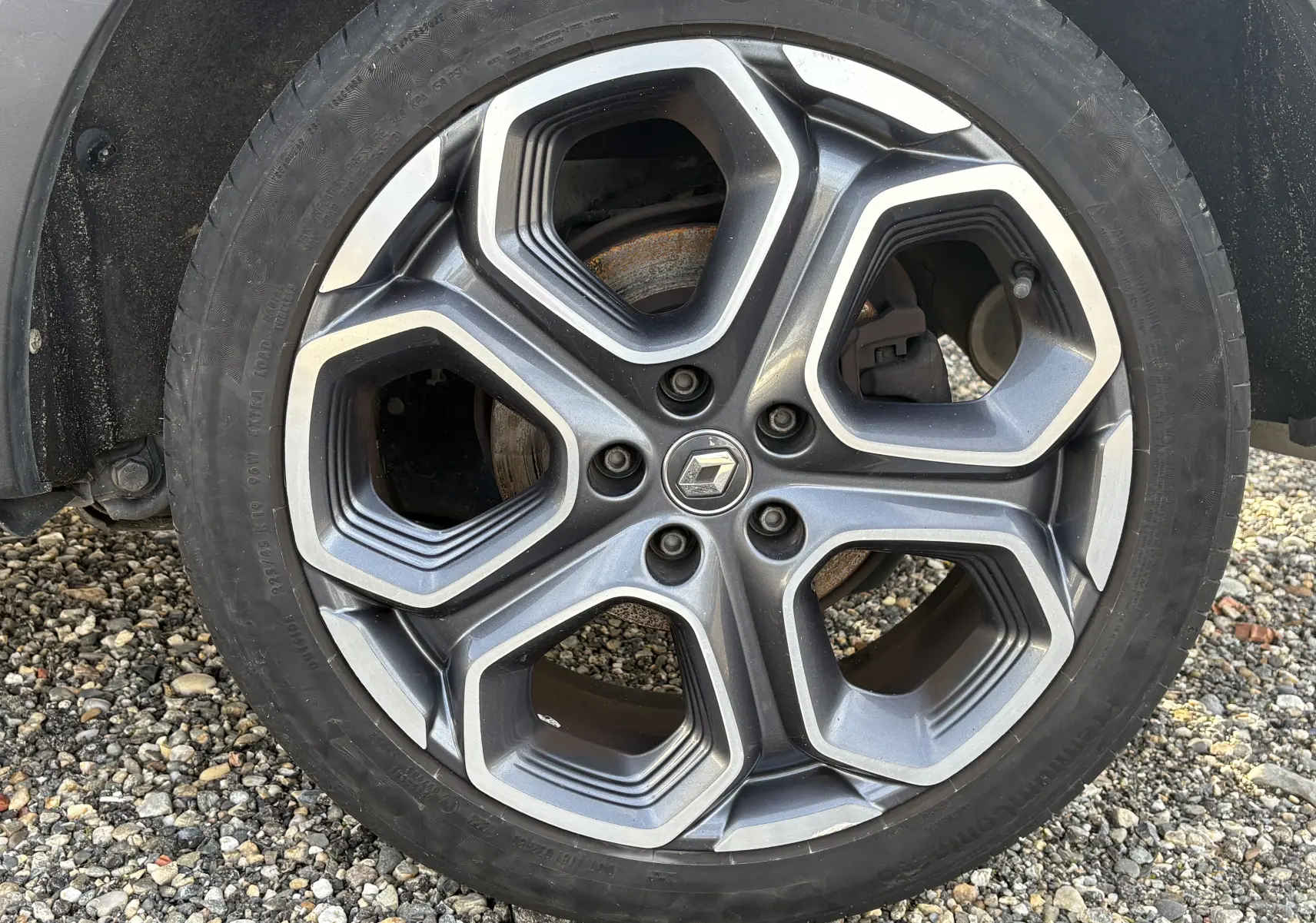 Gros plan sur la roue avant gauche d'un Renault Kadjar blanc 2015, avec jante alliage et pneu Continental.