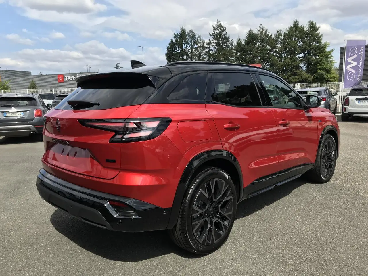 Vue 3/4 arrière droite du Renault Austral 2025 bi-ton rouge et noir avec jantes alliage noires et feux arrière LED.
