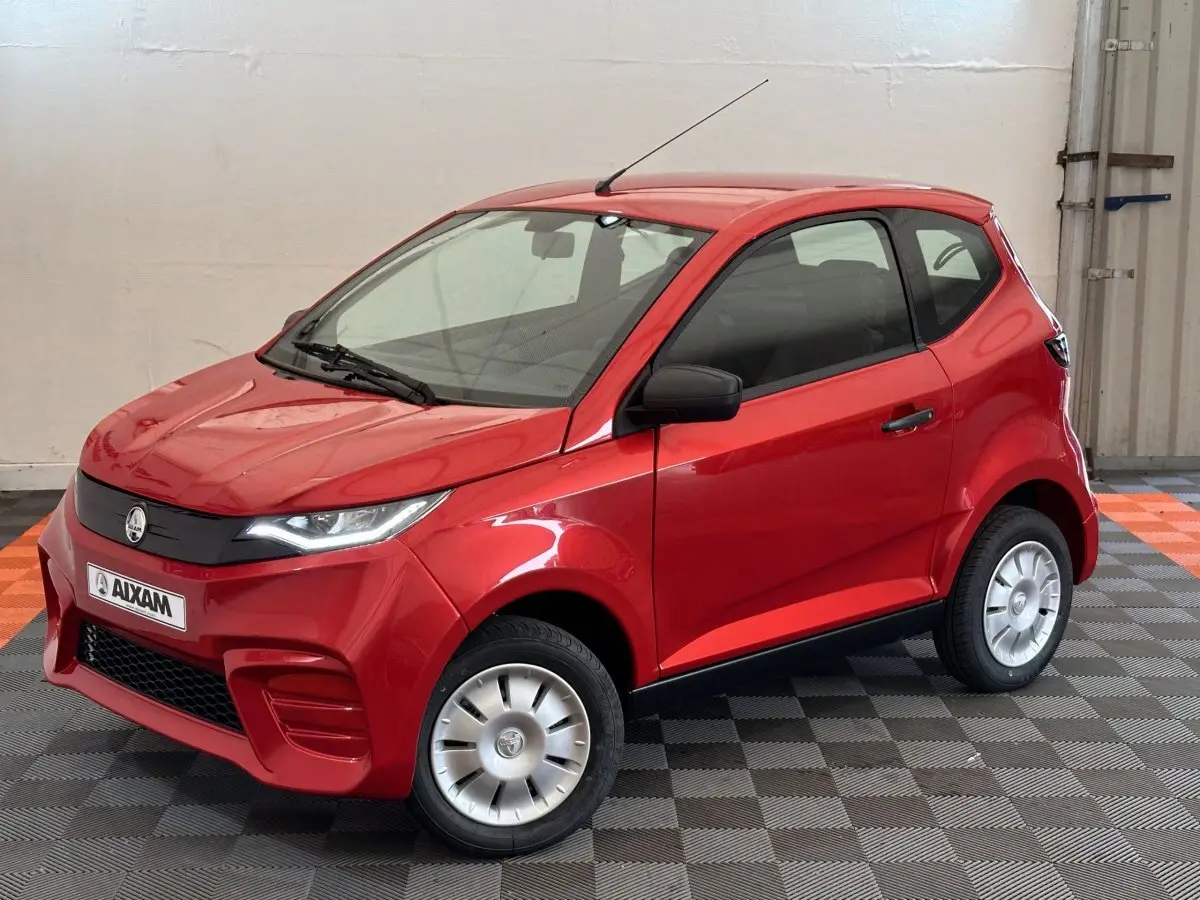 Vue 3/4 avant d'une Aixam Ambition E City Pack rouge 2026 avec rétroviseur caméra côté conducteur.