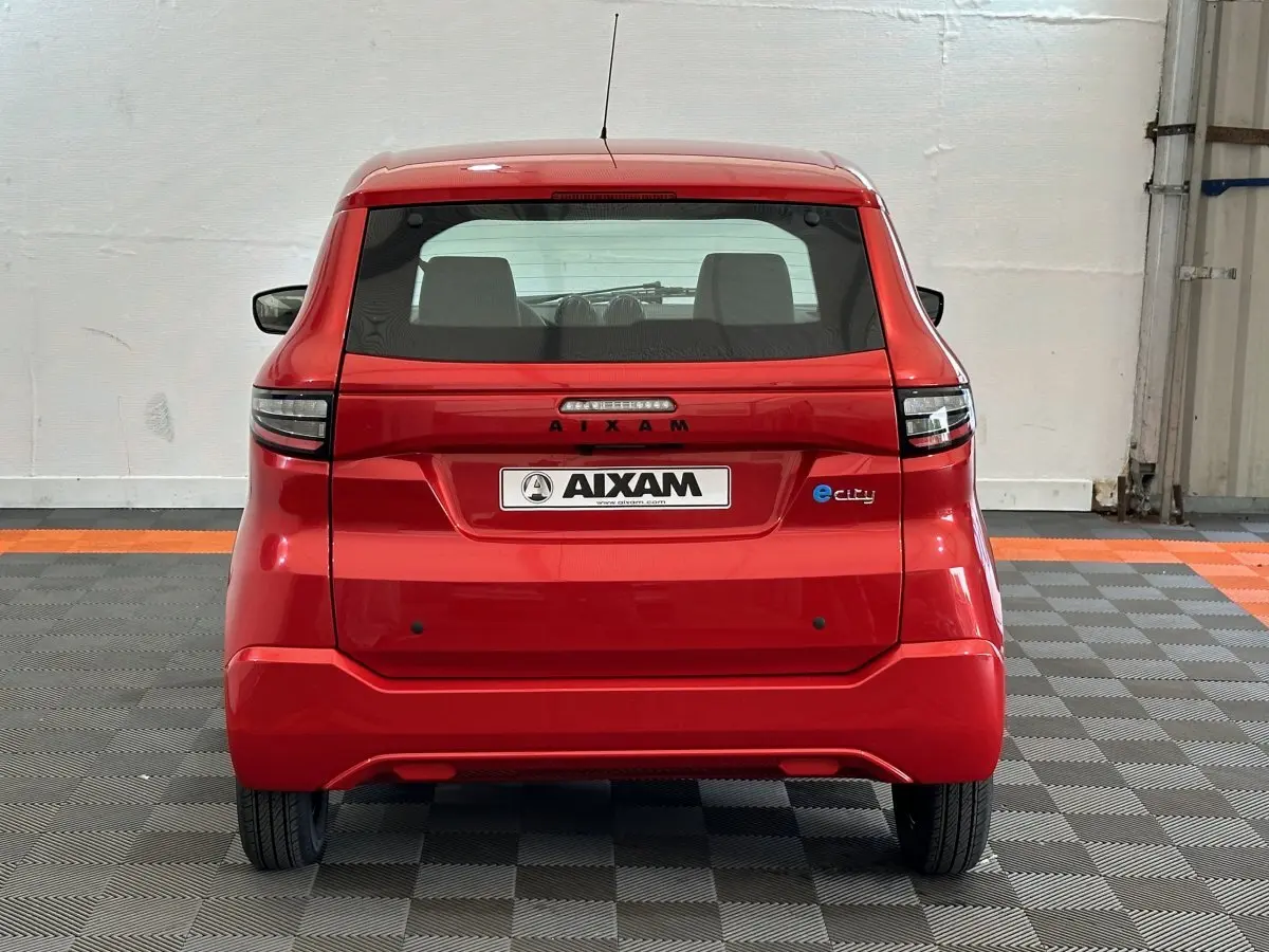 Vue arrière d'une Aixam Ambition E City Pack rouge 2026, avec logo e-city et feux arrière modernes.