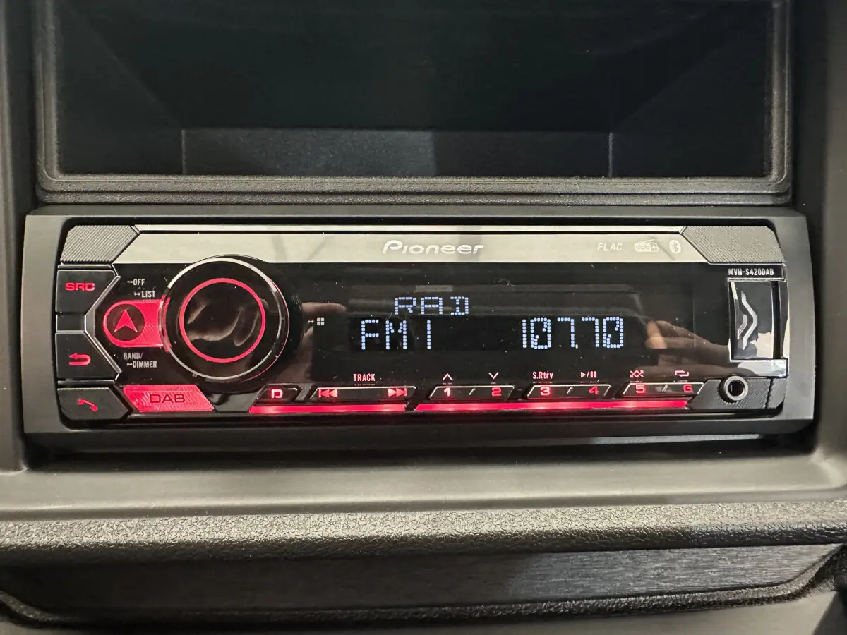 Poste audio Pioneer intégré au tableau de bord d'une Aixam Ambition E City Pack rouge, vue intérieure centrée.