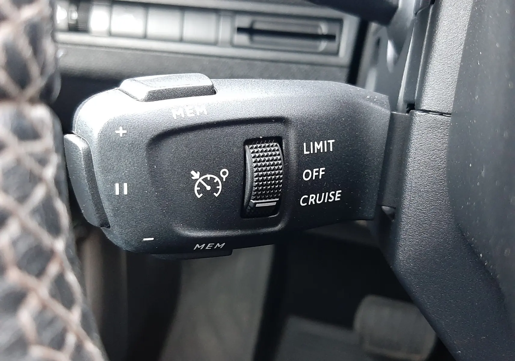 Gros plan sur la commande de régulateur de vitesse du Peugeot 3008 2023, intérieur noir avec molette texturée.