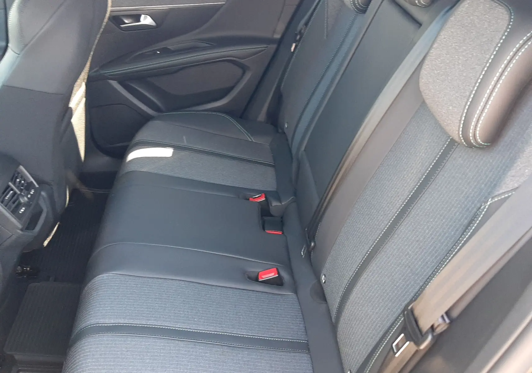 Vue intérieure côté droit montrant la banquette arrière en tissu gris et cuir noir du Peugeot 3008 2023.