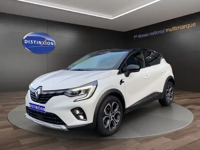 Renault Captur DCI 115 EDC Intens blanc nacré avec toit noir, vue 3/4 avant droit en showroom intérieur.
