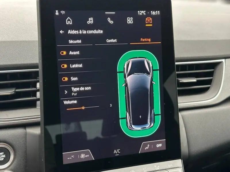 Vue de l'écran central du Renault Captur 2025 montrant l'aide au stationnement avec silhouette noire et contours verts.