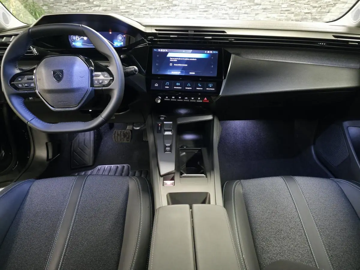 Intérieur noir du Peugeot 408 E--210 Allure 2024, vue de face sur le volant compact et l’écran tactile central.