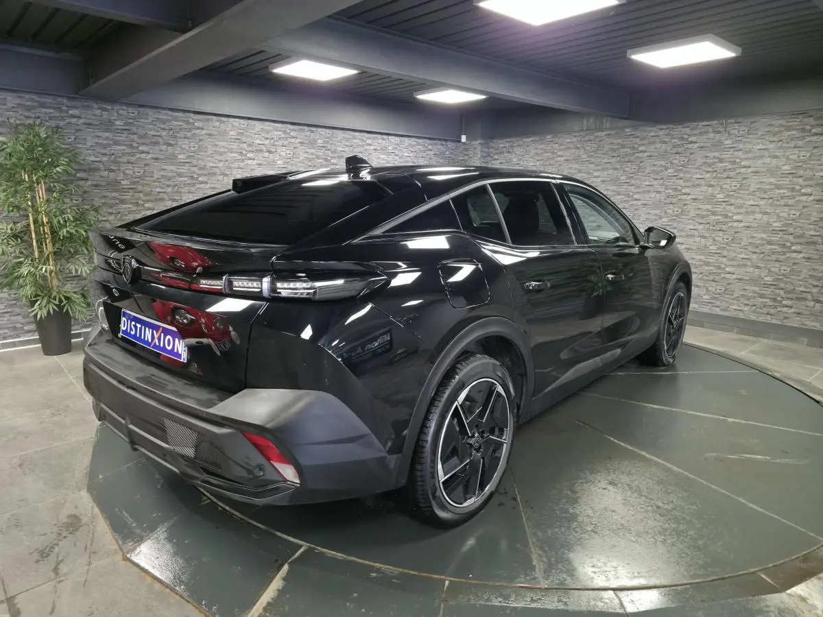 Peugeot 408 électrique noire vue 3/4 arrière droit dans un showroom avec jantes alliage 19 pouces diamantées.
