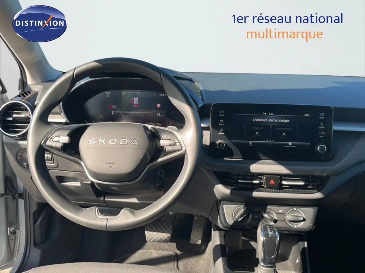 Vue intérieure frontale du tableau de bord et volant Skoda Fabia 2025 en Reflex Silver, avec écran tactile et commandes intégrées.