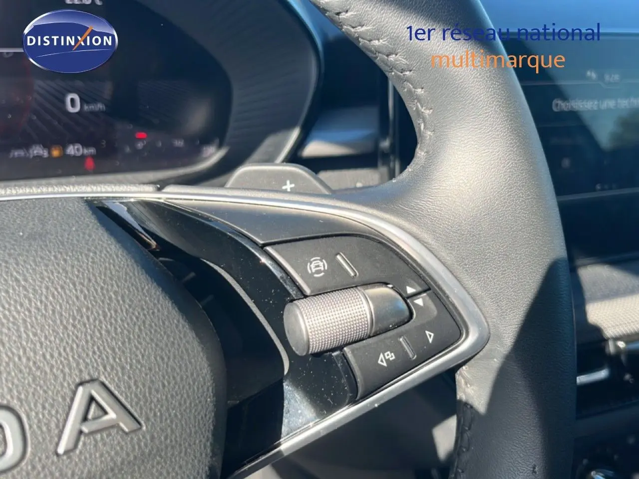 Gros plan sur les commandes au volant en cuir noir de la Skoda Fabia 2025, avec molette et boutons multifonctions visibles.