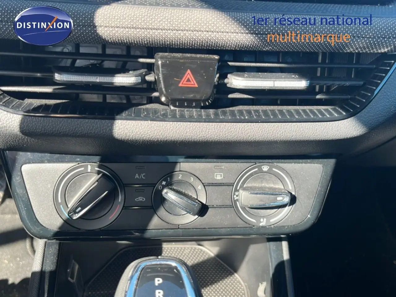 Gros plan sur la console centrale d’une Skoda Fabia 2025 en Reflex Silver, montrant les commandes de climatisation et le levier de boîte automatique.