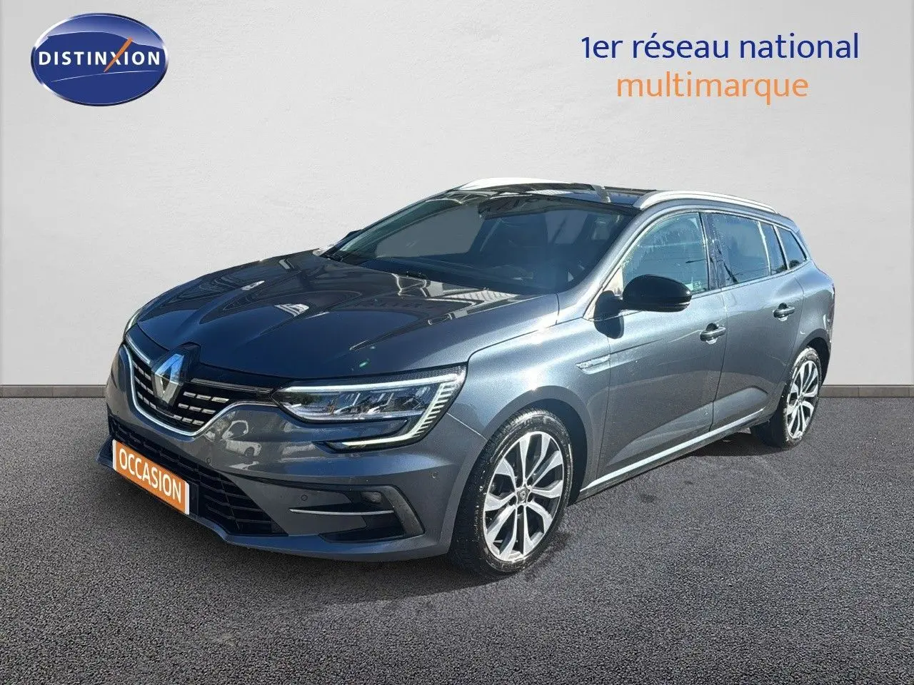 Renault Mégane Break gris titanium métal vue 3/4 avant droit avec jantes alliage et calandre chromée.