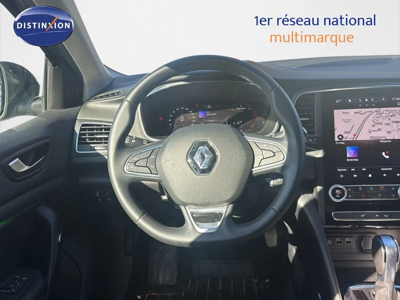 Vue intérieure centrée sur le volant Renault d'une Mégane Break 2024 avec tableau de bord numérique et écran tactile.