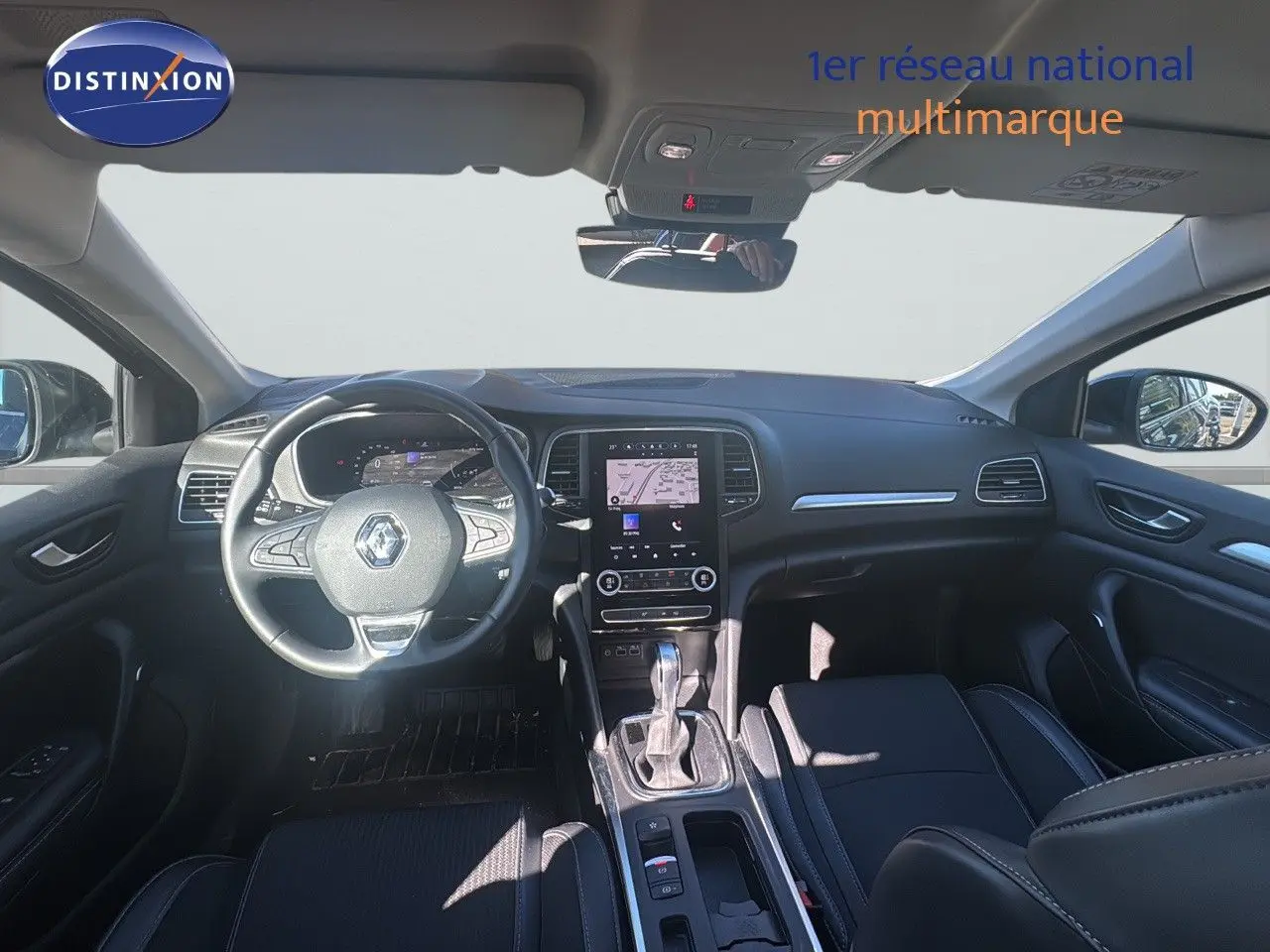 Vue intérieure avant du Renault Mégane Break 2024 avec tableau de bord noir et écran tactile central.