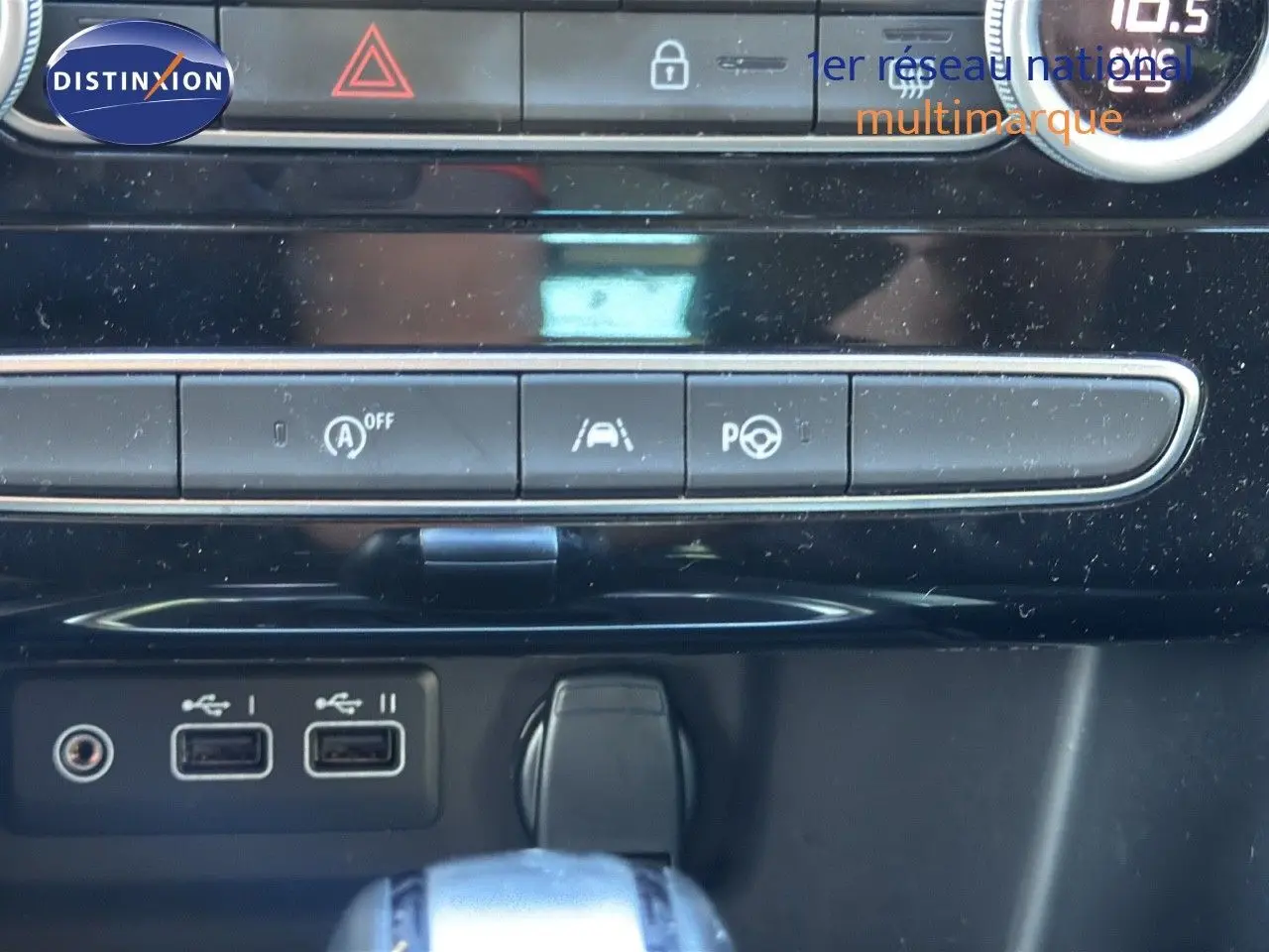 Gros plan sur la console centrale de la Renault Mégane Break gris titanium, montrant les ports USB et commandes de conduite assistée.