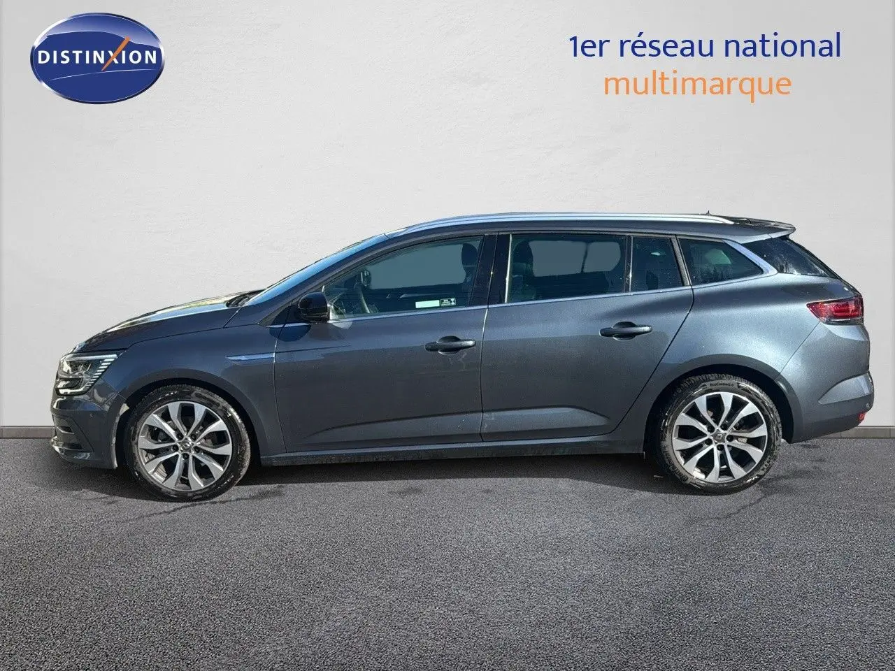 Profil droit d'une Renault Mégane Break gris titanium métal 2024 avec jantes alliage bicolores et vitres teintées.