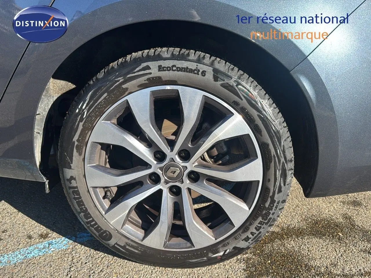 Gros plan sur la roue avant droite d'une Renault Mégane Break gris titanium métal avec jante alliage à dix branches.