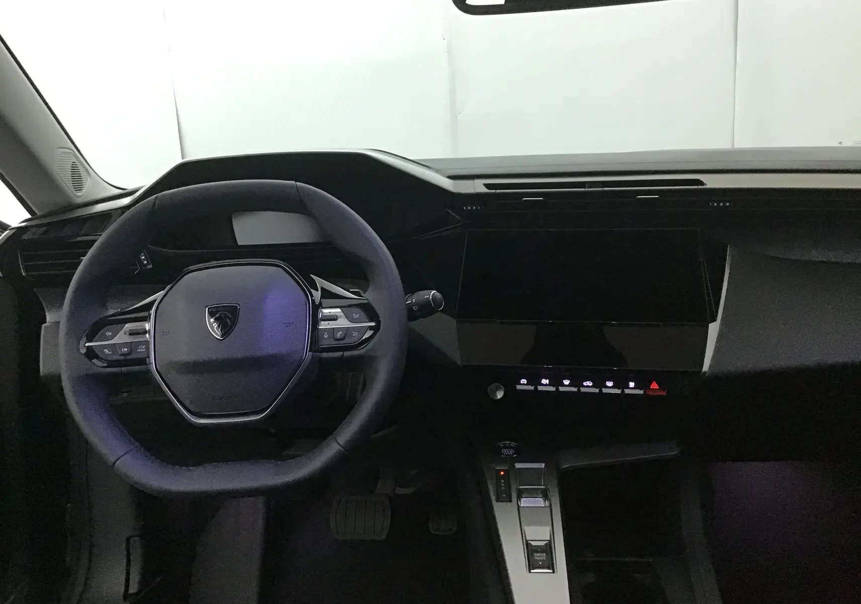 Vue intérieure du tableau de bord et volant compact de la Peugeot 308 gris Sellenium avec écran tactile et commandes intégrées.