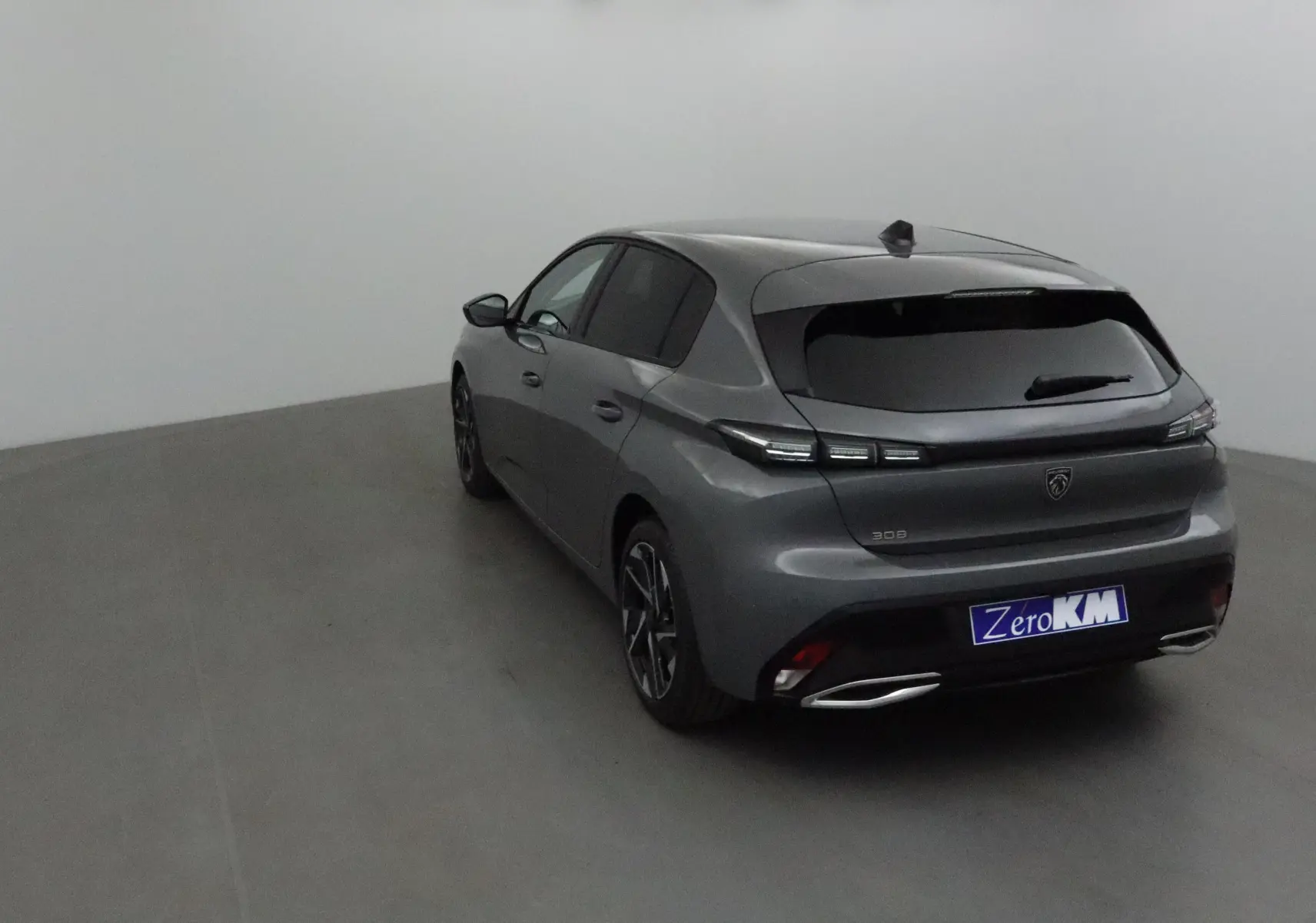 Peugeot 308 gris Sellenium vue 3/4 arrière droit, avec feux arrière LED et double sortie d'échappement chromée.