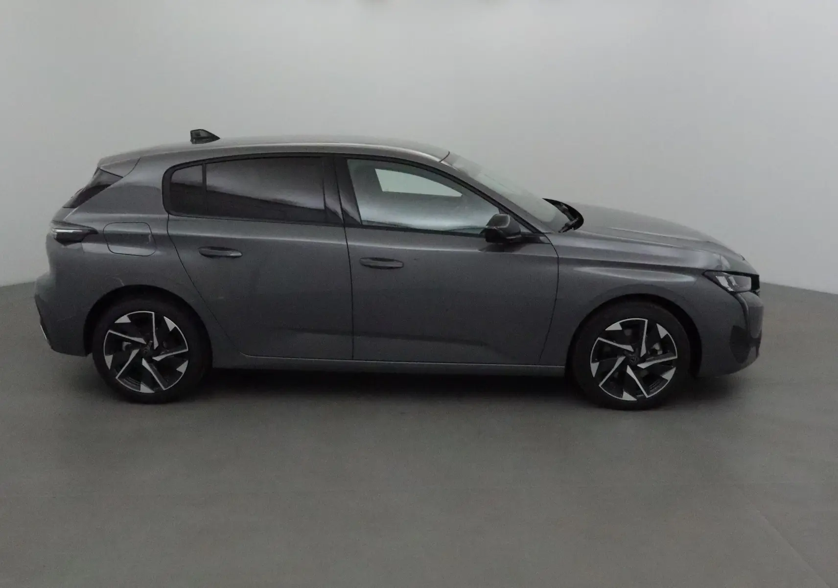 Profil côté gauche d'une Peugeot 308 gris Sellenium 2025 avec jantes alliage et vitres teintées.