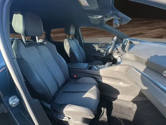 Intérieur du Peugeot 3008 bleu Célèbes 2023, vue côté gauche sur les sièges avant en tissu et tableau de bord moderne.