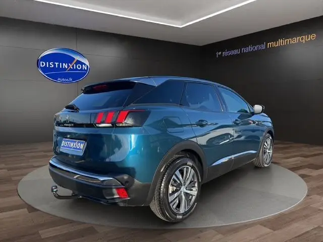 Vue 3/4 arrière droite d'un Peugeot 3008 bleu Célèbes 2023 avec feux arrière à griffes et jantes alliage.