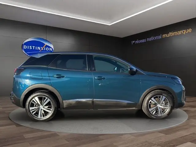 Profil latéral droit d'un Peugeot 3008 bleu Celebes 2023 dans un showroom avec jantes alliage et lignes épurées.