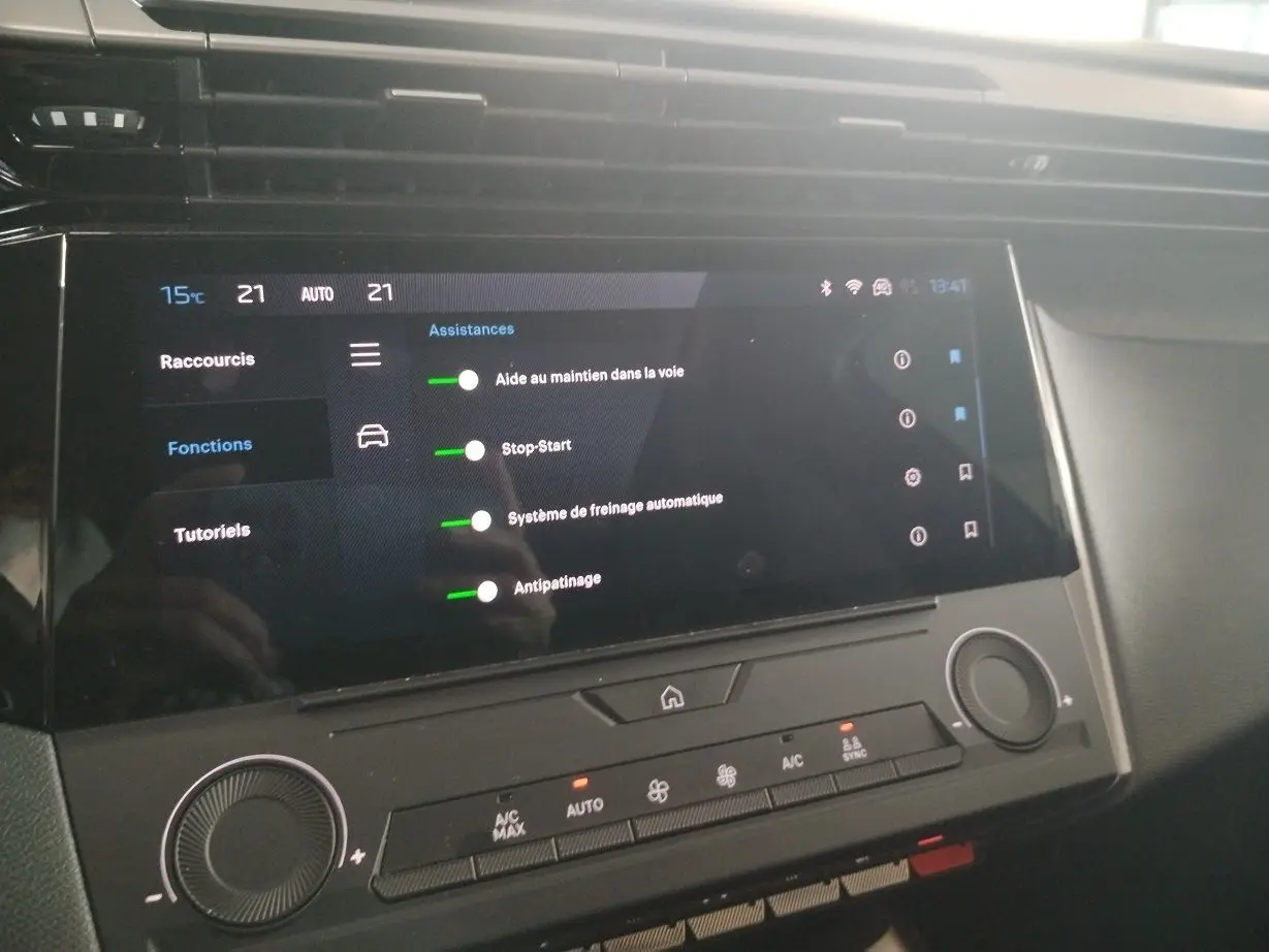 Écran tactile central affichant les assistances à la conduite dans l’habitacle d’une Peugeot 308 SW gris Artense.