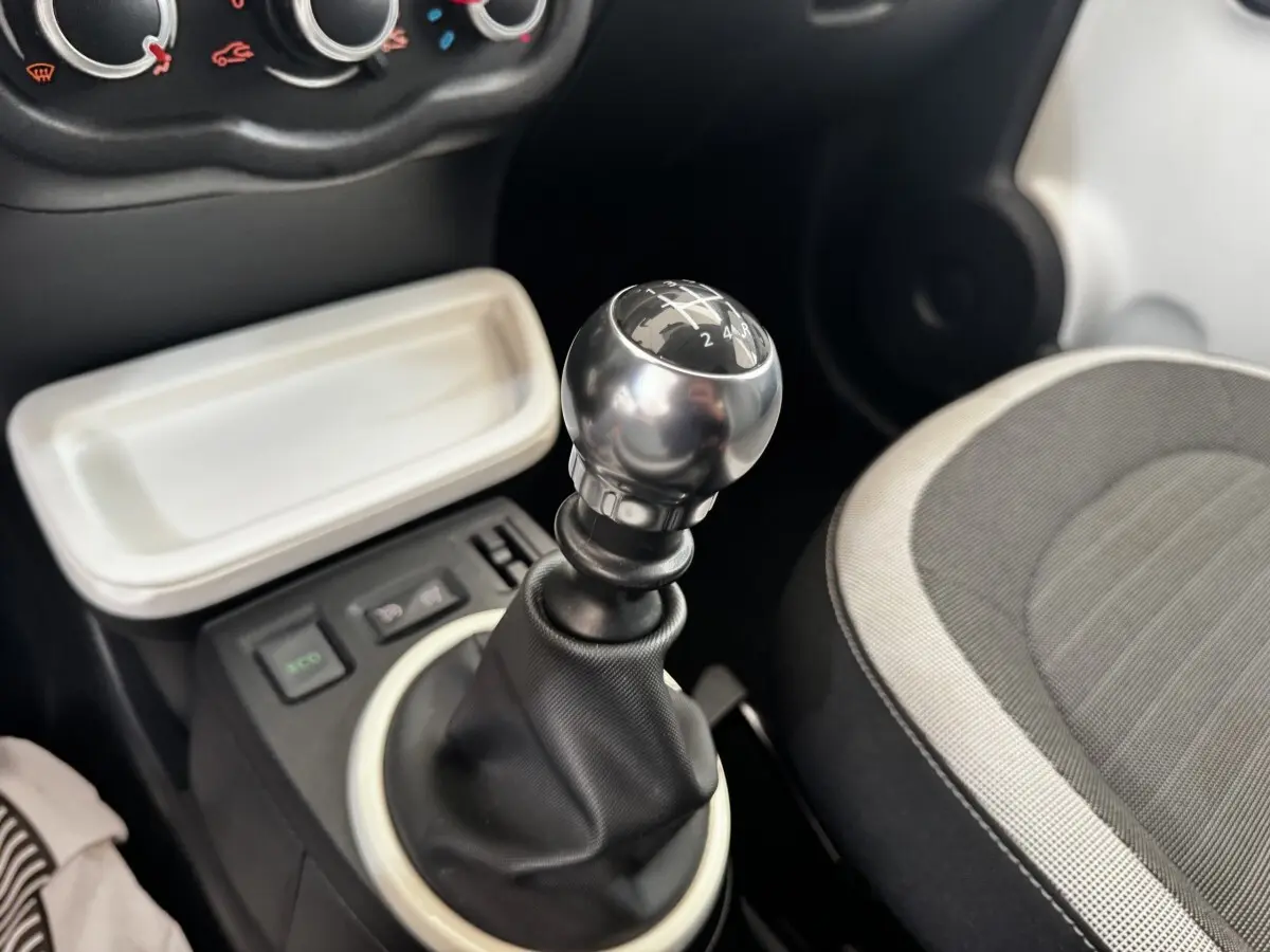 Gros plan sur le levier de vitesses manuel gris métallisé et siège tissu gris clair de la Renault Twingo Intense Energy 2016.