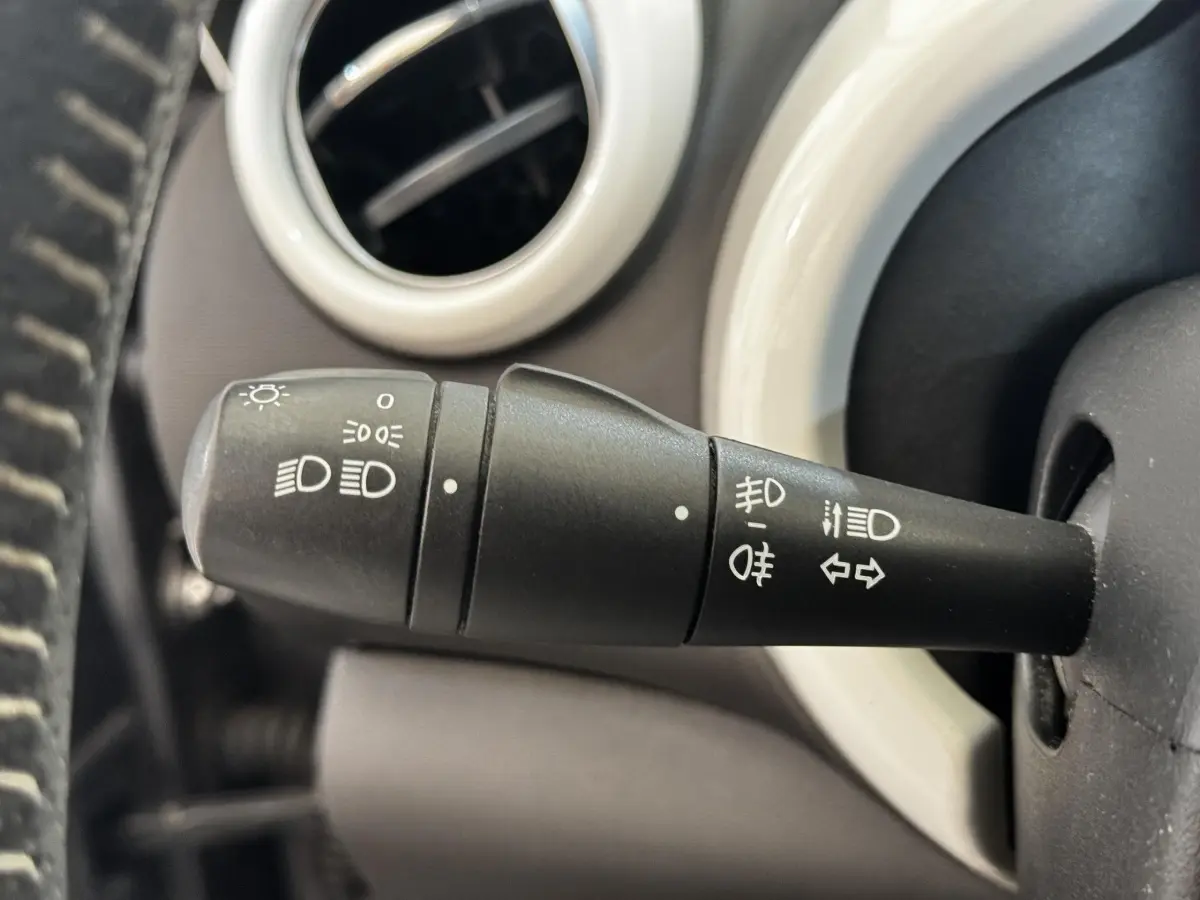 Gros plan sur la commande des phares et clignotants dans l’habitacle gris d’une Renault Twingo Intense Energy TCe 90.