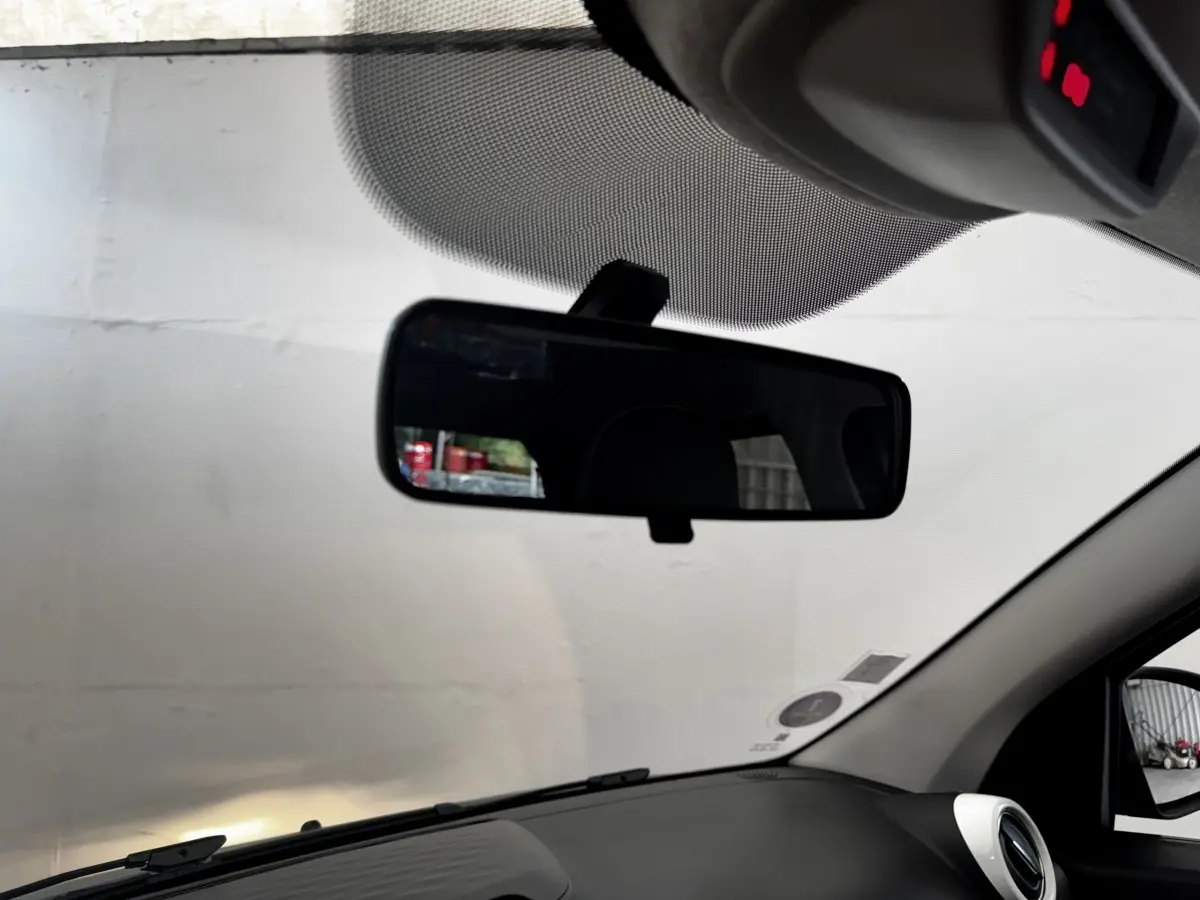 Vue intérieure du tableau de bord et rétroviseur central de la Renault Twingo Intense Energy TCe 90, avec pare-brise et montant droit visibles.