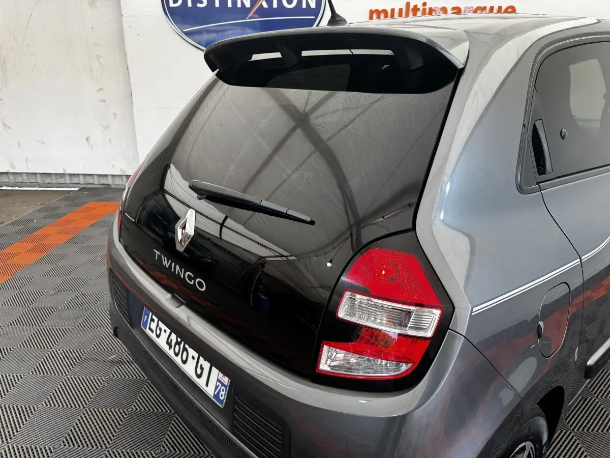 Vue 3/4 arrière droite d'une Renault Twingo Intense Energy TCe 90 gris foncé avec hayon noir et feux arrière rouges.