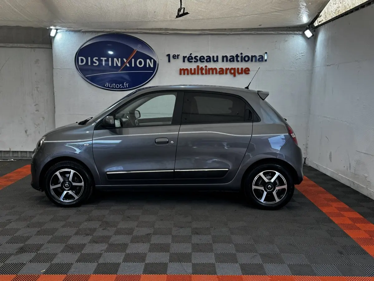 Profil droit d'une Renault Twingo Intense Energy TCe 90 gris foncé, compacte avec jantes alliage et antenne de toit.