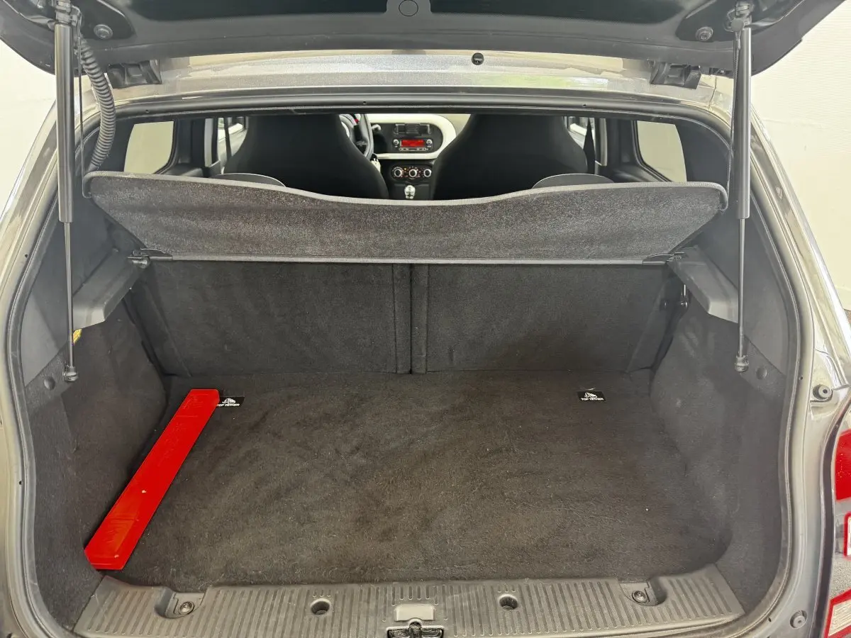 Vue arrière du coffre ouvert d'une Renault Twingo gris foncé, avec banquette arrière et intérieur visible.