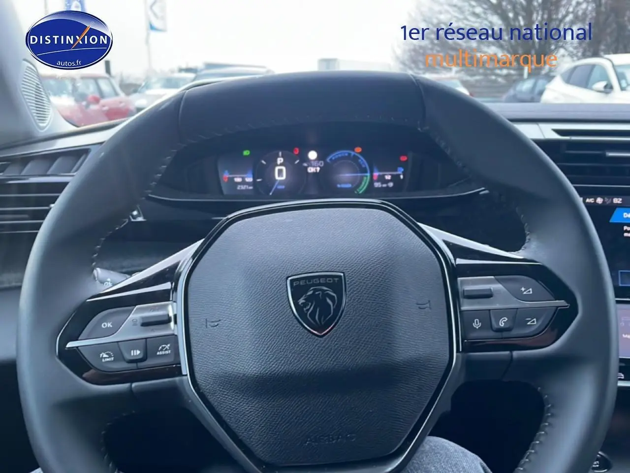 Vue rapprochée du volant multifonction noir de la Peugeot 308 1.2 hybrid 145 allure e-dcs6, tableau de bord numérique visible.