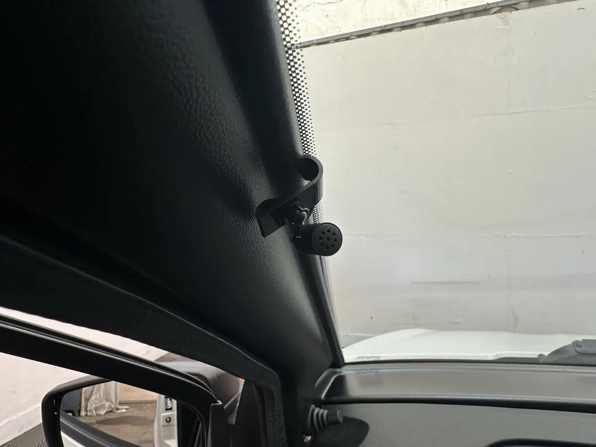 Vue intérieure côté conducteur montrant la caméra intégrée au rétroviseur extérieur d'une Aixam Ambition E City Pack blanche.