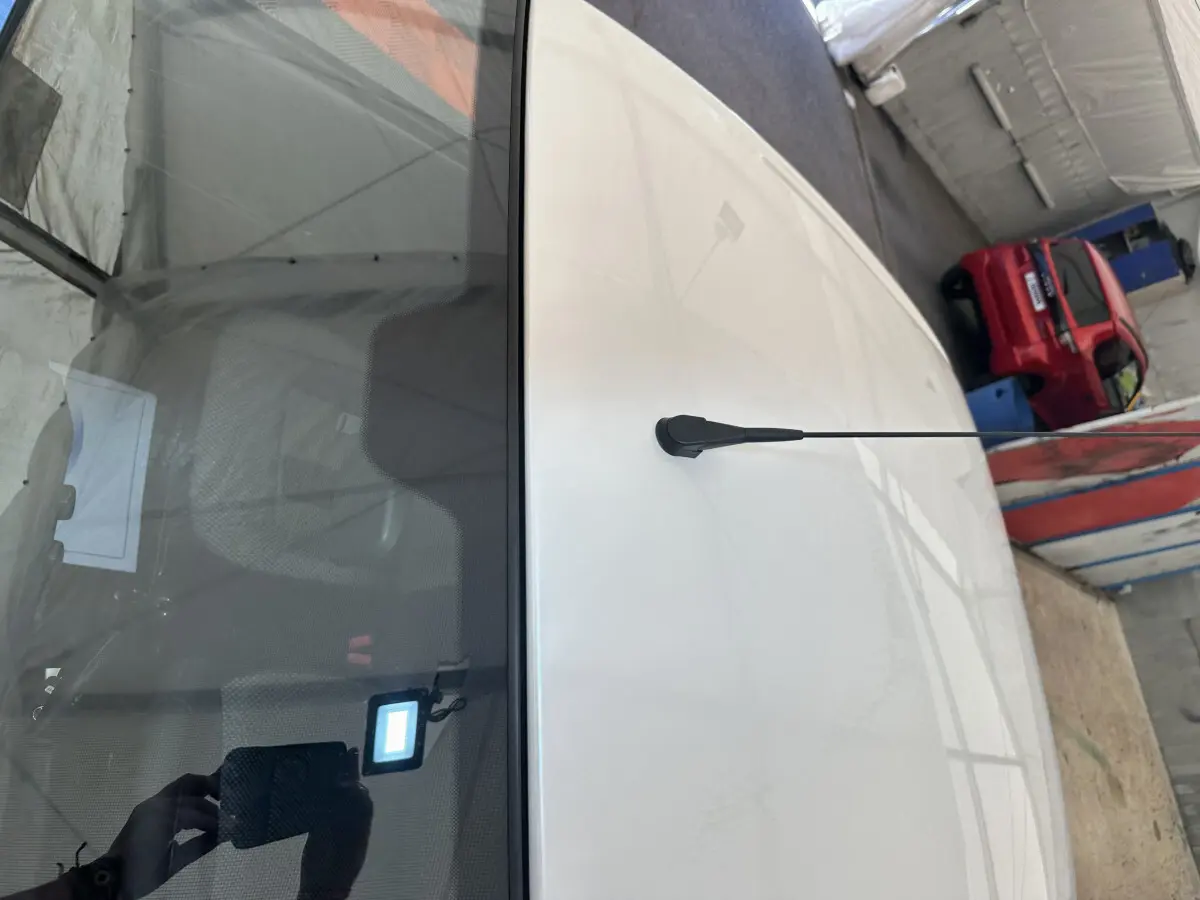 Vue plongeante sur le toit blanc d'une Aixam Ambition E City Pack 2026 avec antenne et rétroviseur caméra côté conducteur.