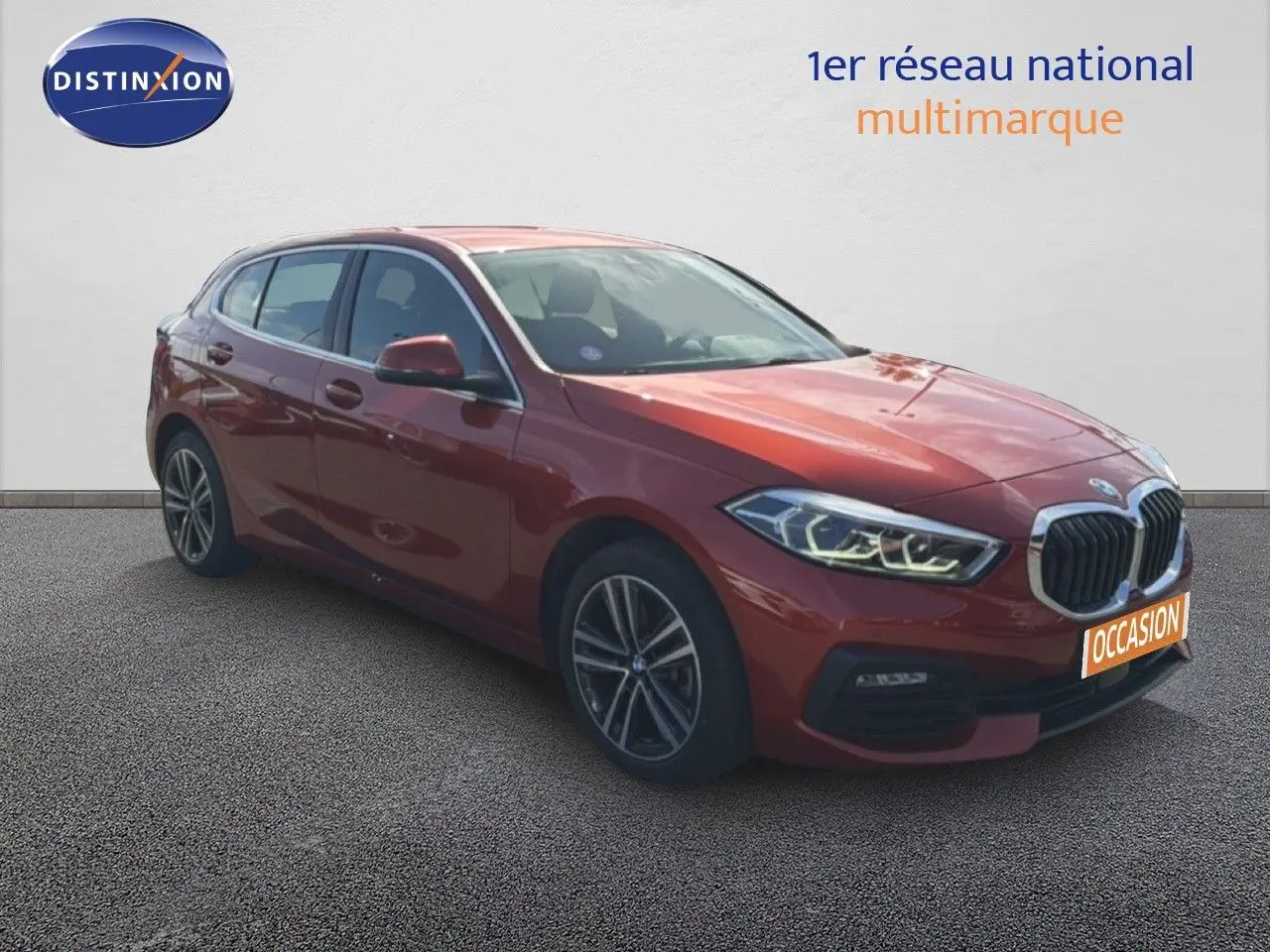 BMW Série 1 116i orange Sunset vue 3/4 avant droit avec phares LED et jantes alliage biton.