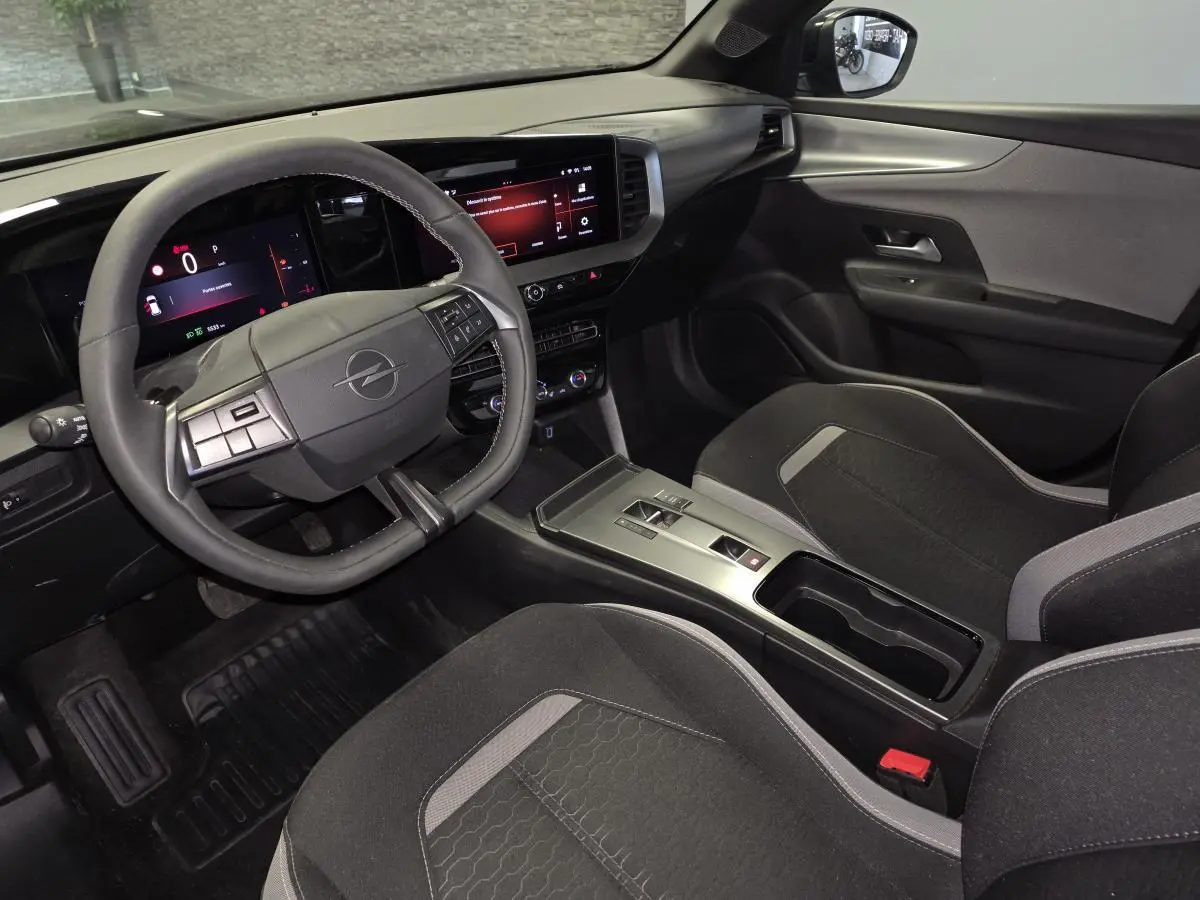 Vue intérieure côté conducteur de l'Opel Mokka 2025, volant TEP, écran tactile 10'', sellerie tissu noir et gris.