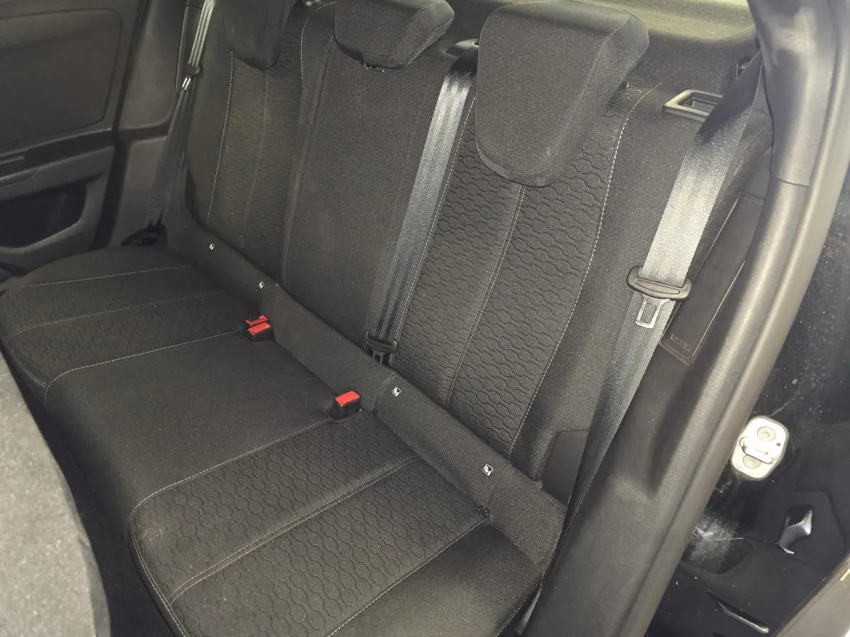 Vue intérieure de la banquette arrière noire de l'Opel Mokka 2025, avec ceintures de sécurité visibles.