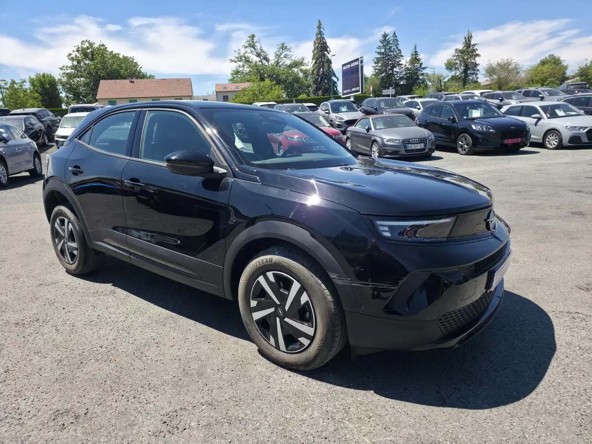 Vue 3/4 avant droite d'un Opel Mokka noir avec calandre Vizor noire et jantes en acier 16 pouces au parking.