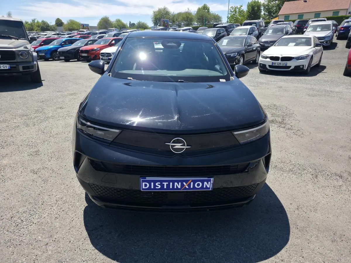 Vue avant d'un Opel Mokka noir avec calandre Vizor noire et logo Opel argenté, en extérieur sur parking.